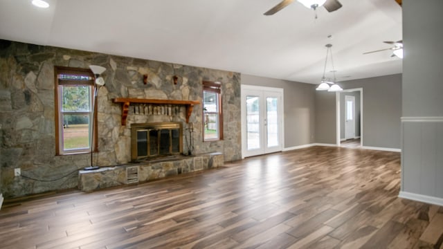 unfurnished living room with dark wood-type flooring, ceiling fan, a fireplace, and vaulted ceiling