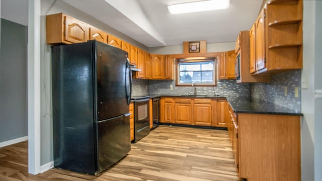 kitchen with sink, light hardwood / wood-style floors, backsplash, and black appliances