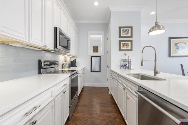 kitchen with pendant lighting, crown molding, sink, appliances with stainless steel finishes, and white cabinetry