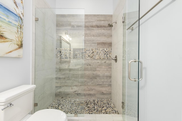 bathroom with an enclosed shower and toilet