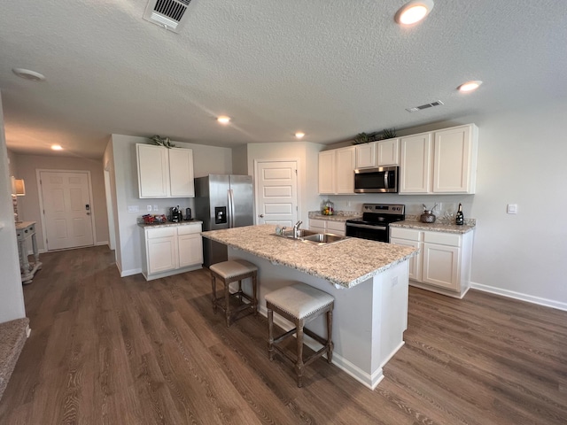 kitchen with white cabinets, sink, a kitchen island with sink, and appliances with stainless steel finishes