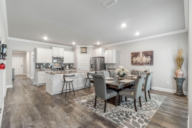 dining area featuring dark hardwood / wood-style flooring and ornamental molding