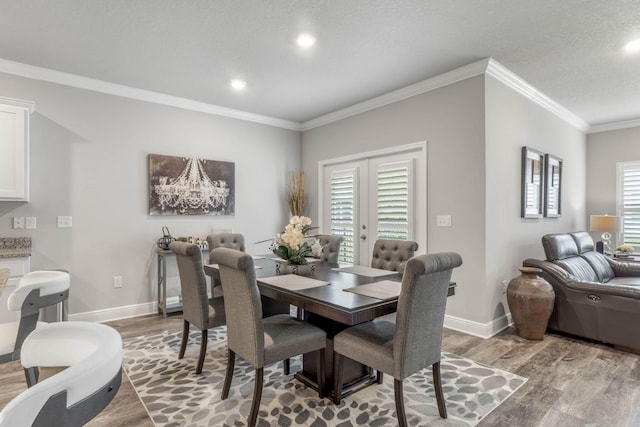 dining area with french doors, a textured ceiling, light hardwood / wood-style floors, and crown molding