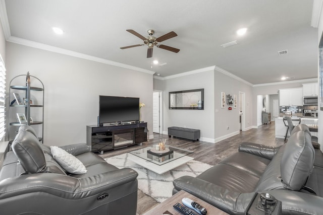 living room with ceiling fan, ornamental molding, and light hardwood / wood-style flooring