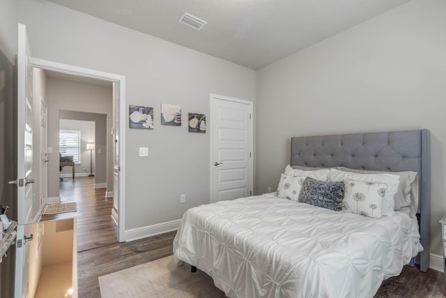 bedroom with dark wood-type flooring