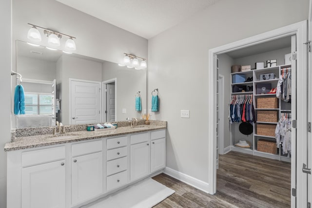 bathroom with hardwood / wood-style floors, vanity, and a textured ceiling