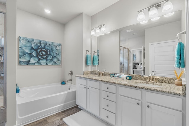 bathroom featuring hardwood / wood-style floors, vanity, and independent shower and bath