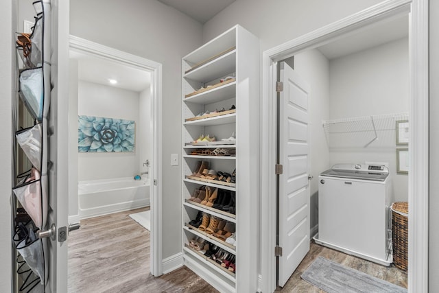 spacious closet with light hardwood / wood-style floors and washer / dryer