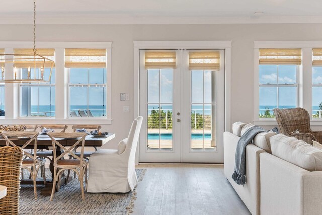 dining space featuring a chandelier, hardwood / wood-style flooring, french doors, and crown molding