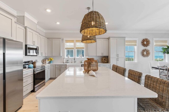 kitchen featuring a wealth of natural light, appliances with stainless steel finishes, backsplash, and a kitchen island