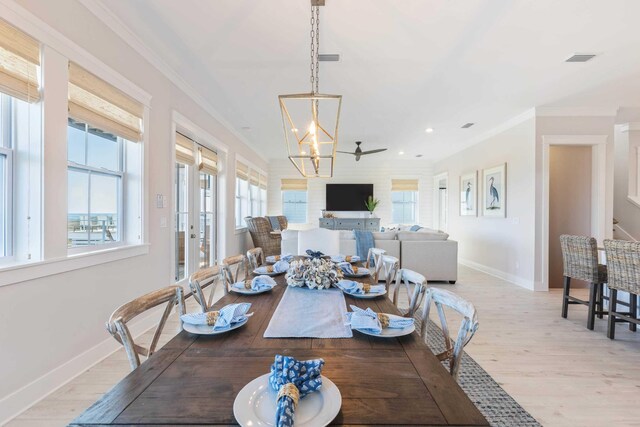 dining room featuring a notable chandelier, light hardwood / wood-style flooring, and crown molding