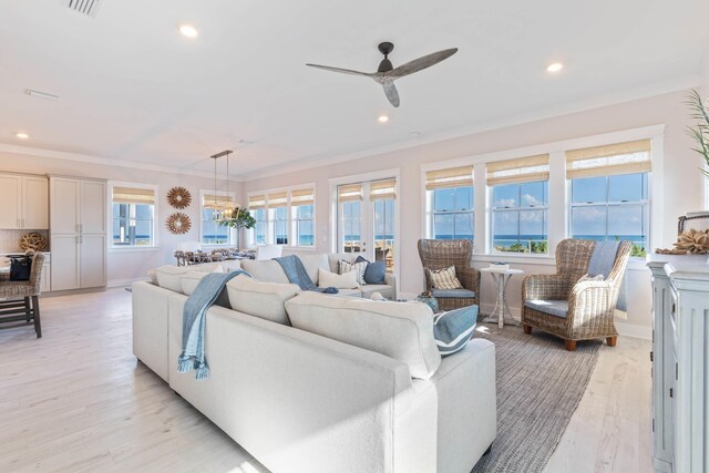 living room with plenty of natural light, ornamental molding, and light hardwood / wood-style flooring