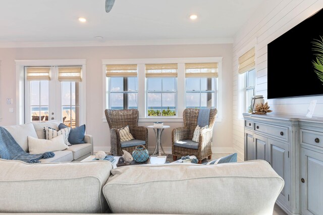 living room with crown molding and a water view