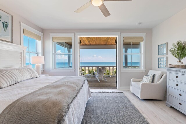 bedroom featuring ceiling fan, light hardwood / wood-style floors, a water view, and access to outside