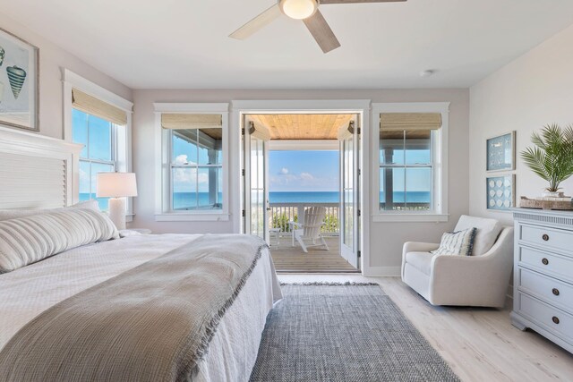 bedroom featuring ceiling fan, a water view, light wood-type flooring, and access to outside