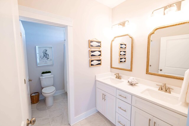 bathroom with tile floors, double sink, toilet, and vanity with extensive cabinet space