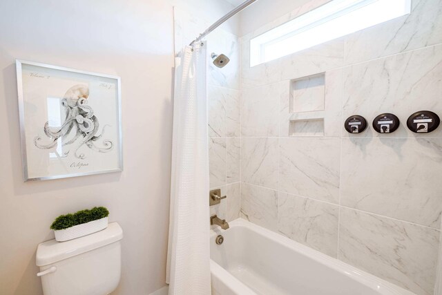 bathroom featuring shower / tub combo and toilet