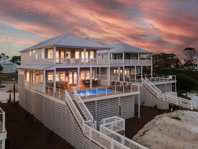 back house at dusk with a patio area and a balcony