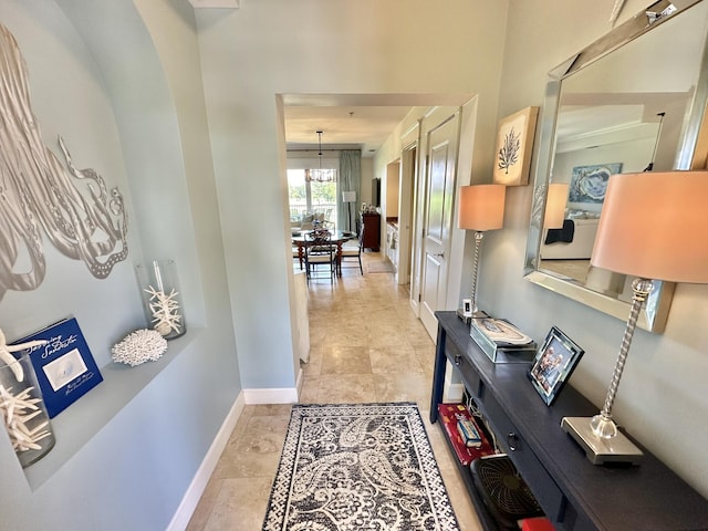 hallway with an inviting chandelier