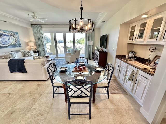 dining space with ceiling fan with notable chandelier, ornamental molding, and sink