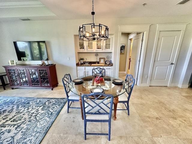 dining room featuring a chandelier, a tray ceiling, and sink