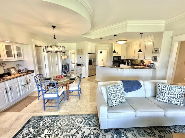 living room featuring a chandelier and ornamental molding