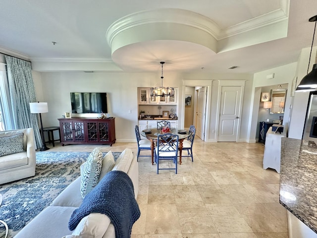 living room featuring a raised ceiling, crown molding, and a notable chandelier