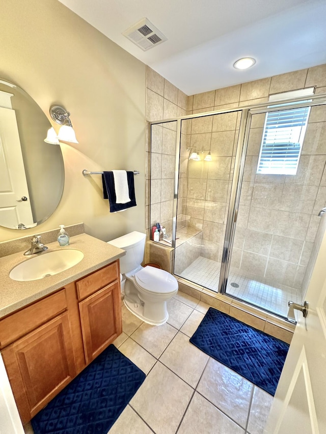 bathroom featuring tile patterned floors, vanity, toilet, and an enclosed shower