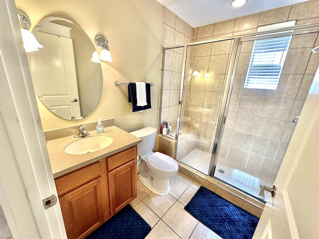 bathroom featuring toilet, vanity, tile patterned floors, and an enclosed shower