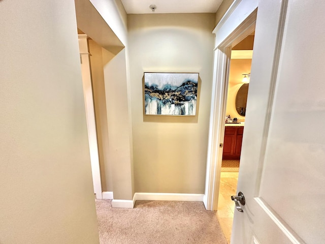 hall with sink and light carpet