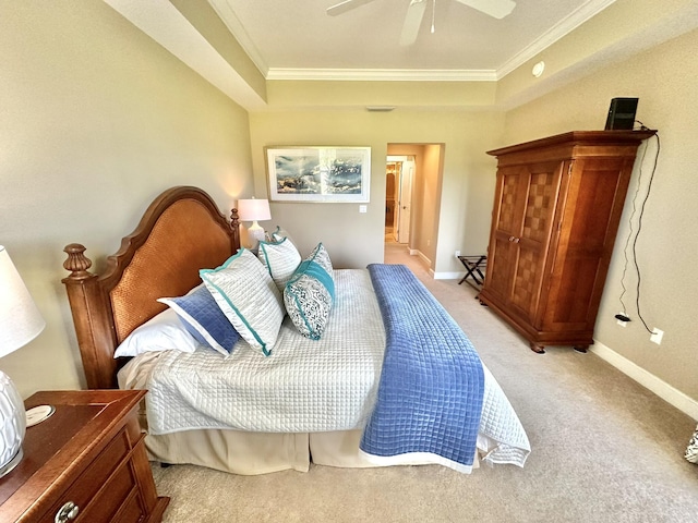 bedroom featuring light colored carpet, ceiling fan, crown molding, and a tray ceiling