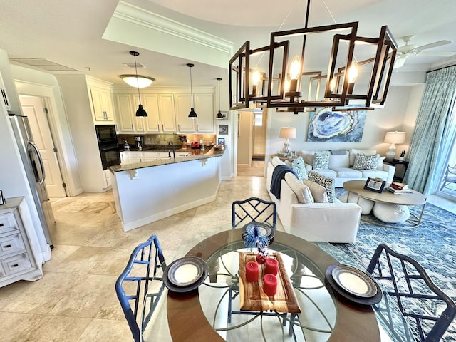 dining space with crown molding and ceiling fan with notable chandelier