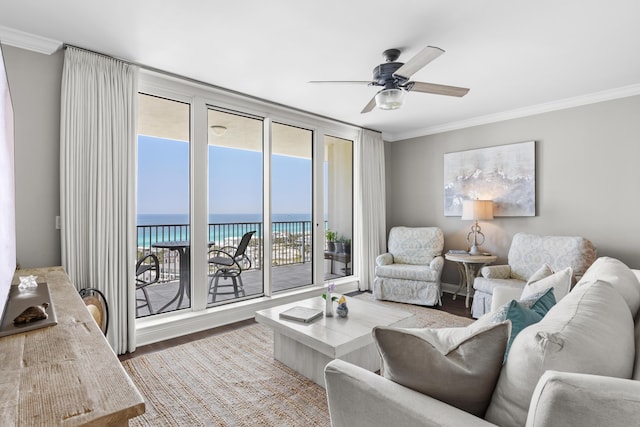 living room with a water view, wood-type flooring, and ornamental molding