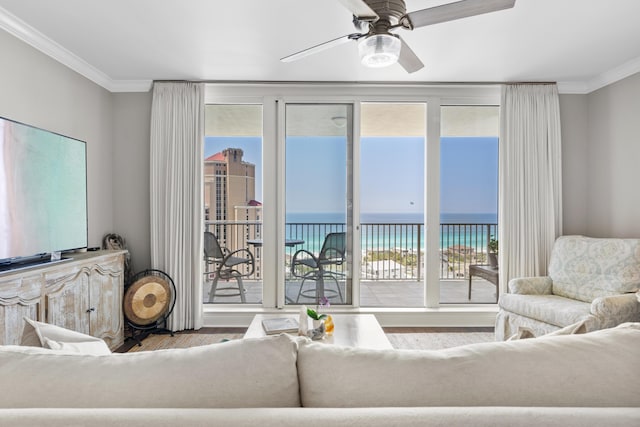 living room with ornamental molding, a water view, ceiling fan, and a healthy amount of sunlight