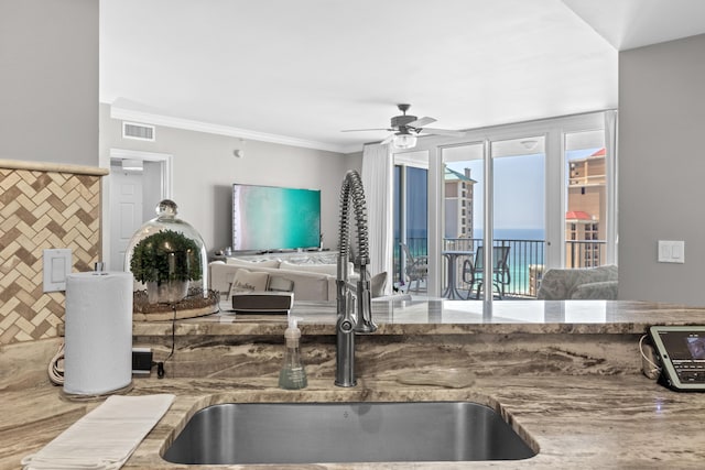 kitchen with ceiling fan, sink, and ornamental molding