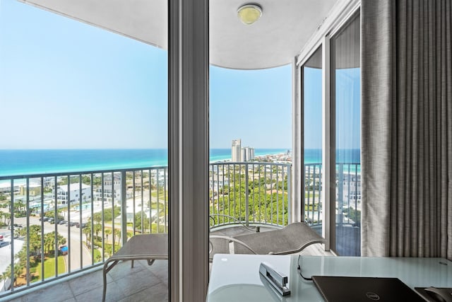 balcony featuring a beach view and a water view