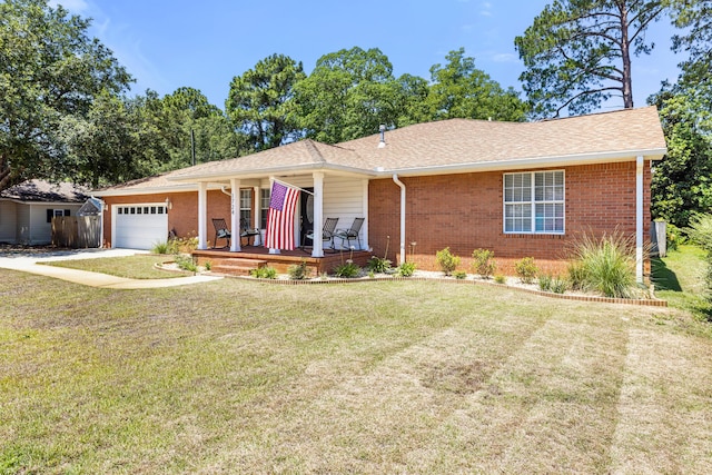 ranch-style house featuring a garage, covered porch, and a front lawn