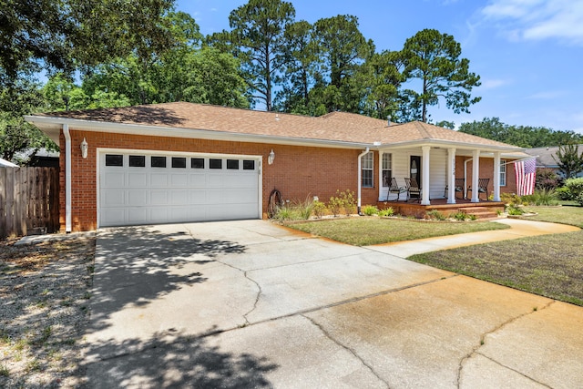 single story home with a garage, a front yard, and covered porch