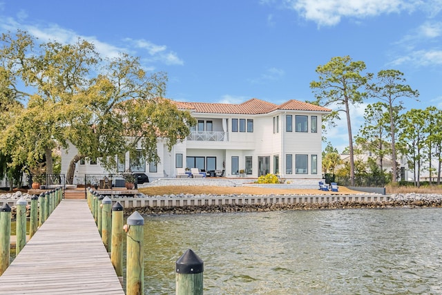 rear view of property featuring a water view and a balcony