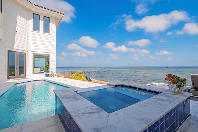 view of pool with a water view, an in ground hot tub, and french doors