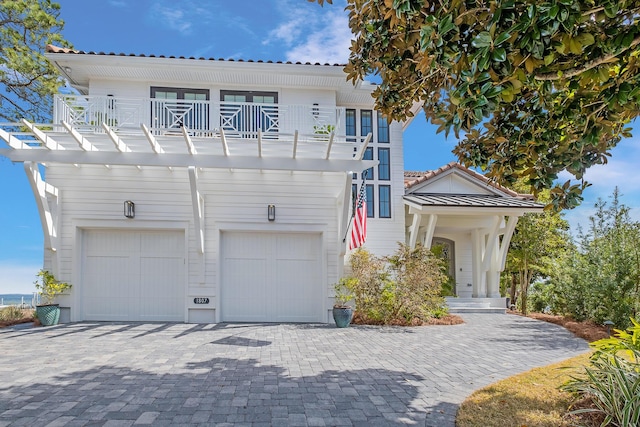 view of front of property featuring a balcony and a garage