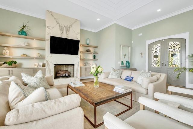 living room with crown molding, a high end fireplace, and french doors