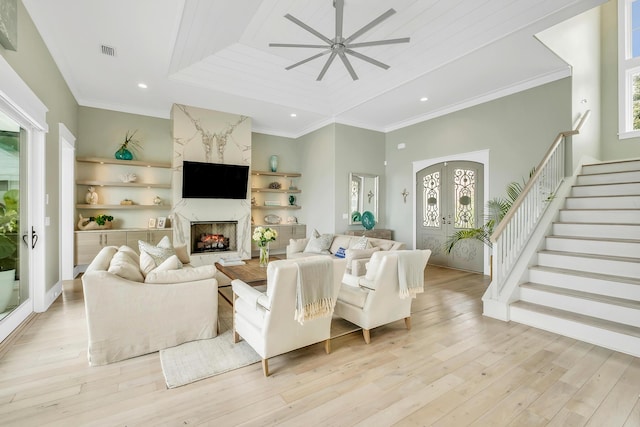 living room with ceiling fan, a healthy amount of sunlight, light hardwood / wood-style floors, and french doors