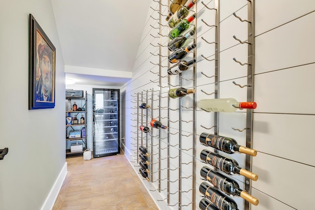 wine room with light hardwood / wood-style floors and vaulted ceiling