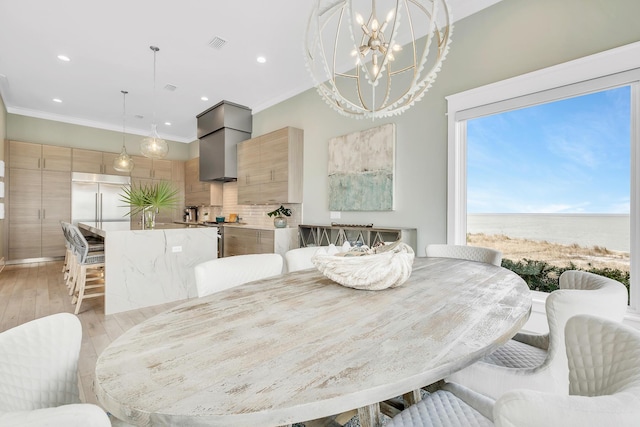 dining area with crown molding, a water view, light hardwood / wood-style floors, and an inviting chandelier