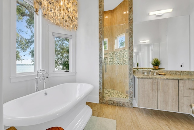 bathroom with vanity, a water view, shower with separate bathtub, and a wealth of natural light