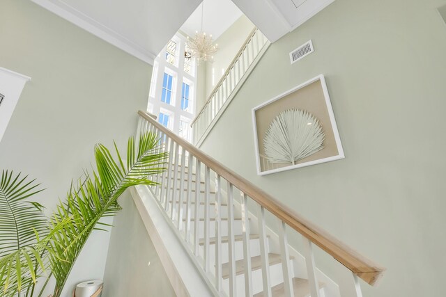 stairs featuring a notable chandelier