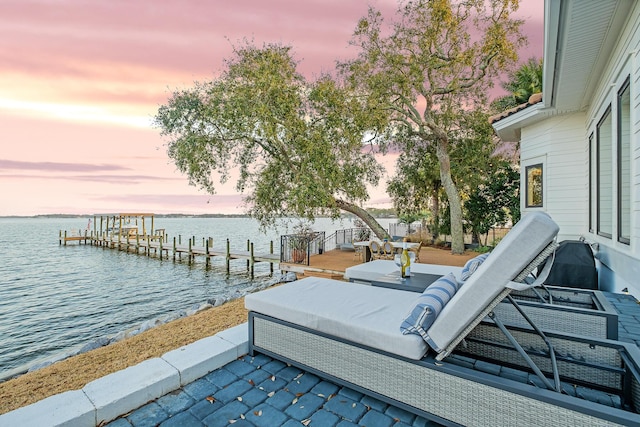 patio terrace at dusk with a boat dock and a water view