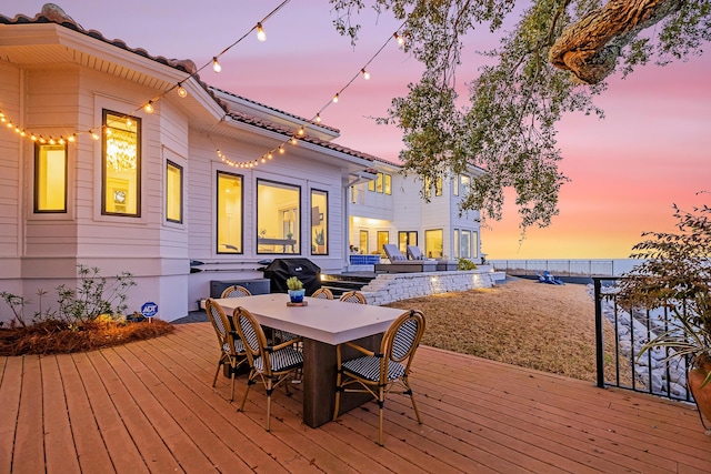 deck at dusk with grilling area