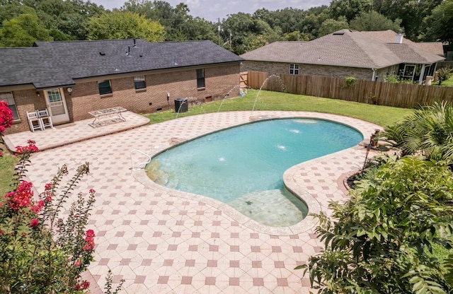 view of pool with cooling unit, a patio, a lawn, and pool water feature